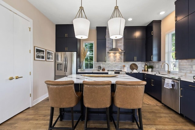 kitchen featuring pendant lighting, light hardwood / wood-style flooring, stainless steel appliances, and a center island