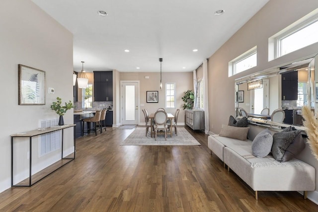 living room with plenty of natural light and dark wood-type flooring