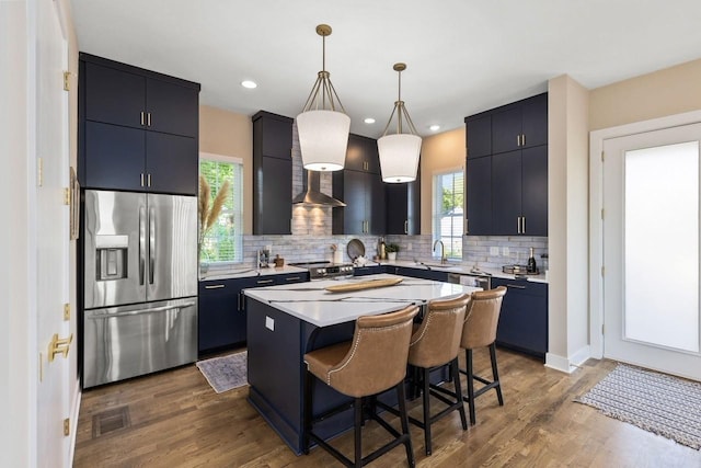 kitchen featuring a kitchen island, decorative light fixtures, sink, a kitchen bar, and stainless steel appliances