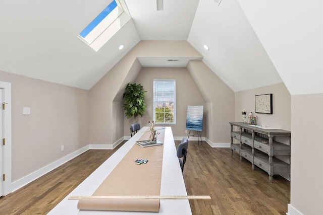 home office featuring dark hardwood / wood-style flooring and vaulted ceiling with skylight