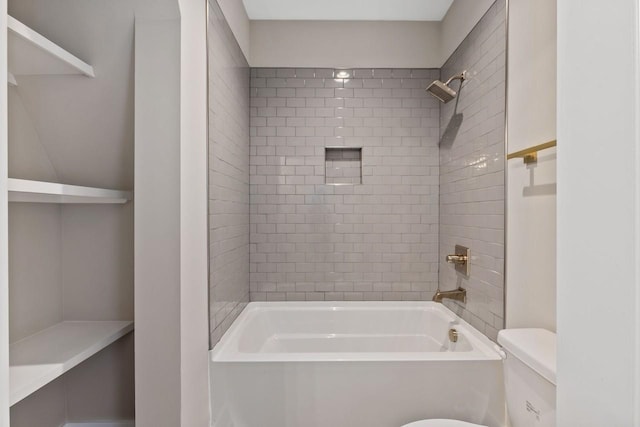 bathroom featuring tiled shower / bath combo and toilet