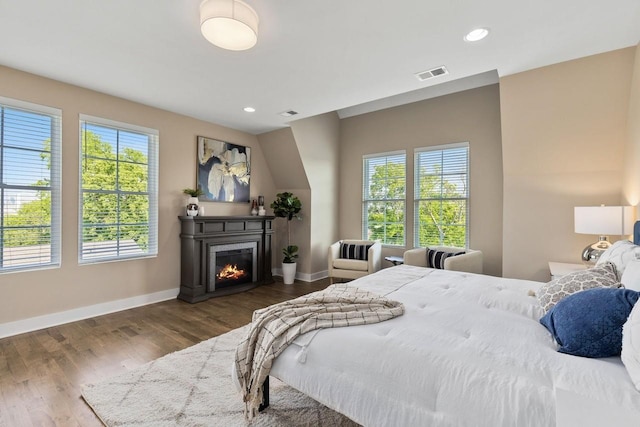 bedroom with multiple windows and dark hardwood / wood-style flooring