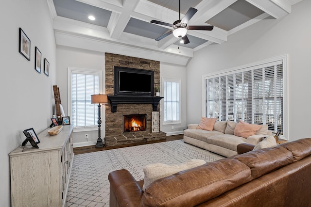 living room featuring coffered ceiling, a stone fireplace, hardwood / wood-style flooring, ceiling fan, and beam ceiling