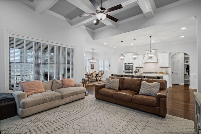 living room with light hardwood / wood-style flooring, ornamental molding, beamed ceiling, and a healthy amount of sunlight