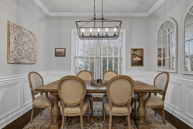 dining room with crown molding, wood-type flooring, and a chandelier