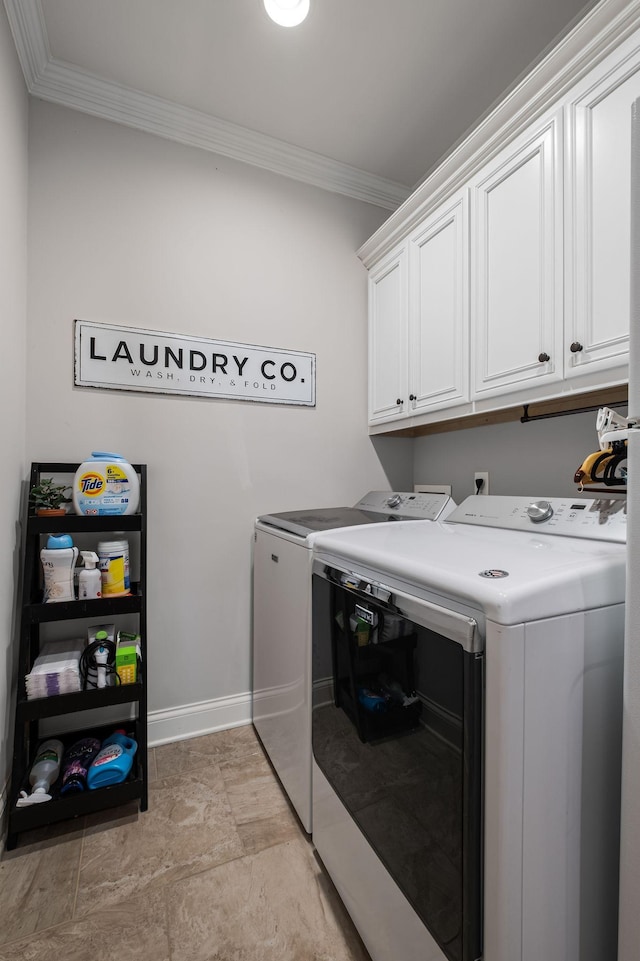 clothes washing area featuring cabinets, washing machine and dryer, and ornamental molding