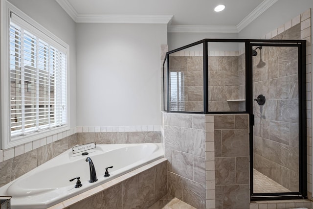 bathroom featuring ornamental molding and separate shower and tub