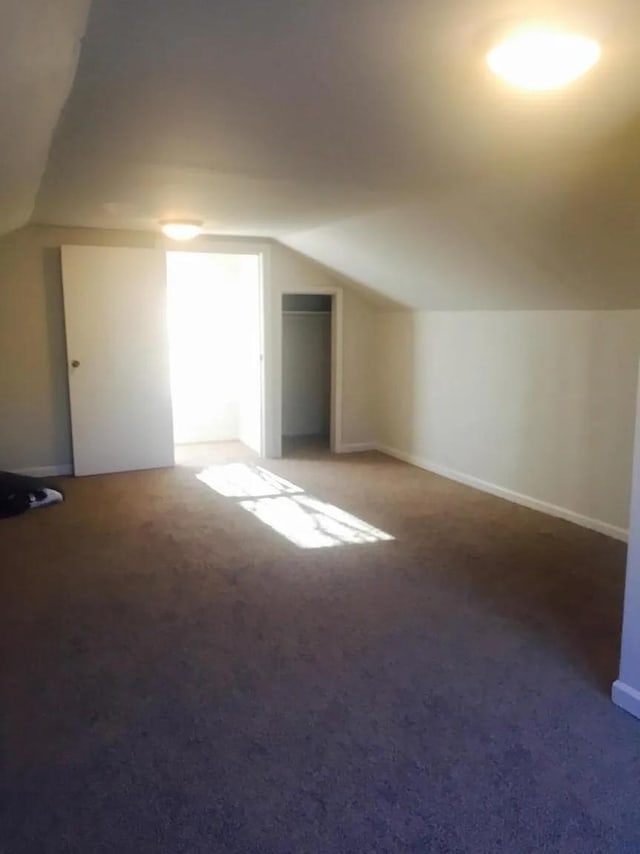 bonus room with carpet floors and vaulted ceiling