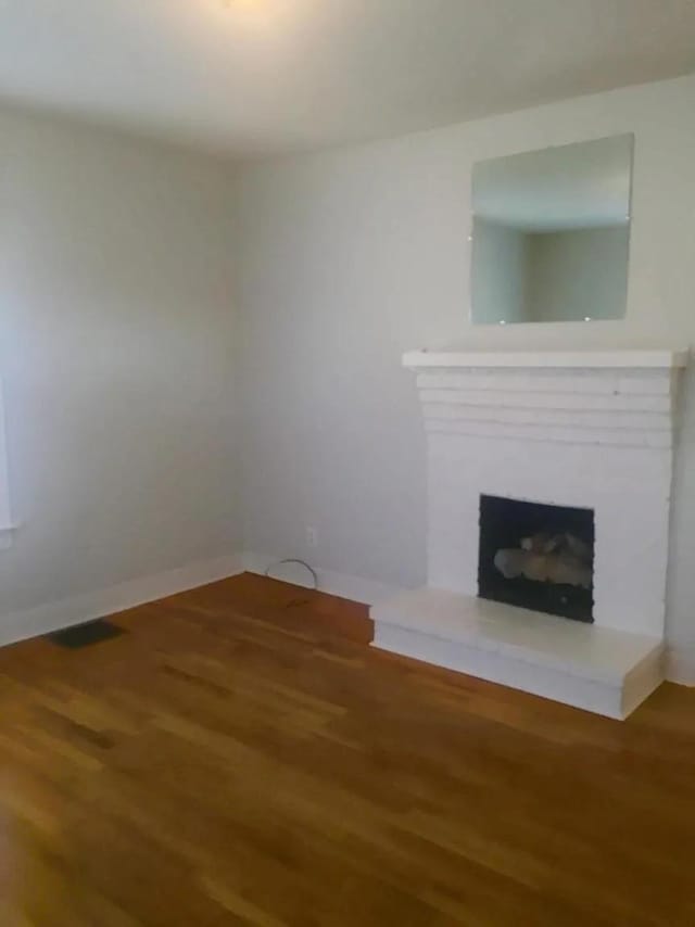 unfurnished living room featuring wood-type flooring and a fireplace