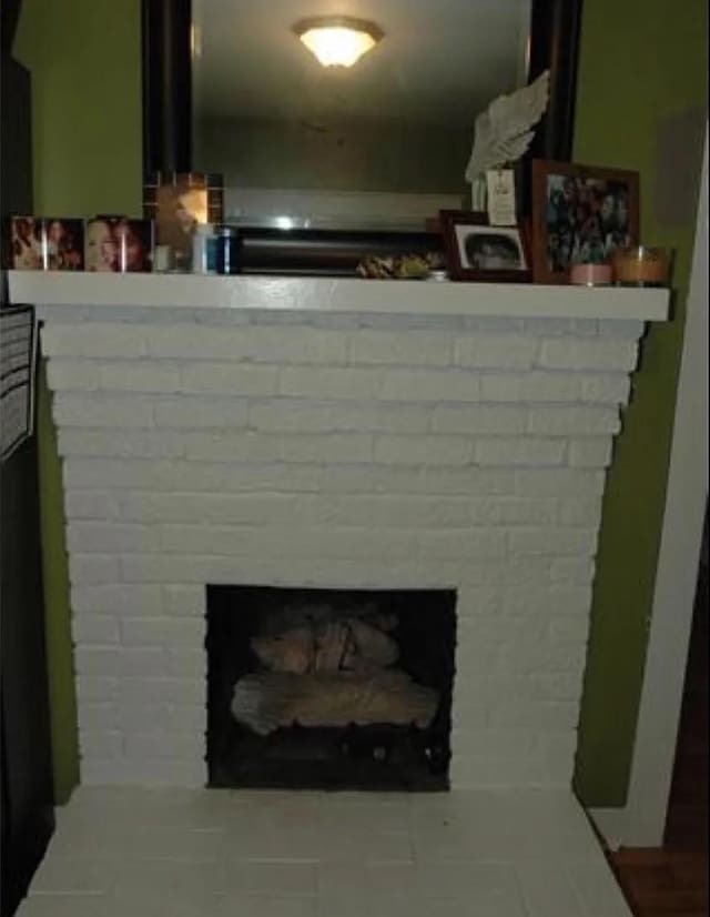 interior details featuring a brick fireplace