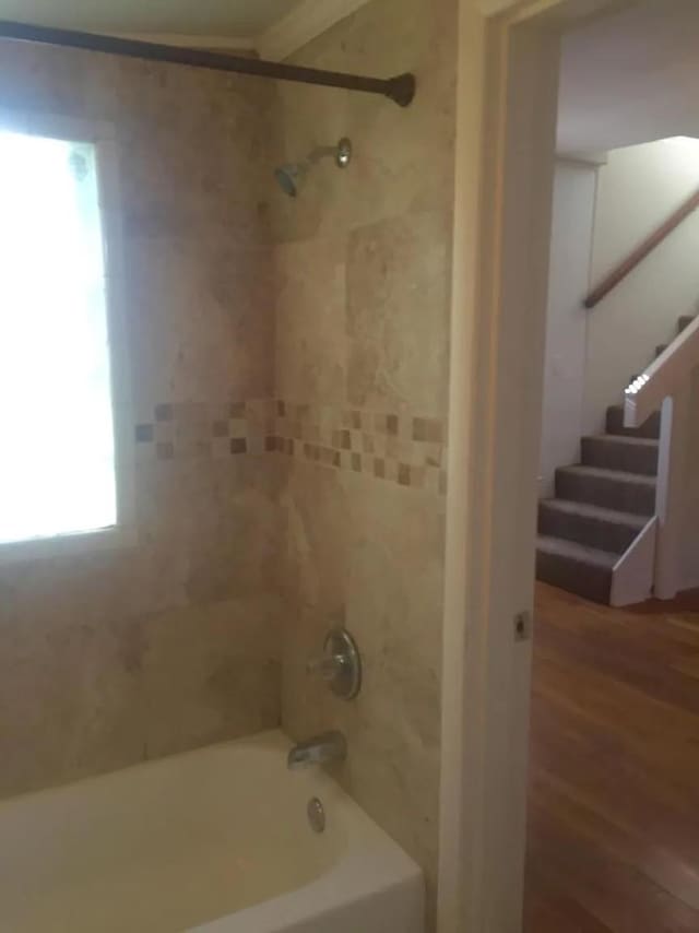 bathroom with tiled shower / bath combo and hardwood / wood-style flooring