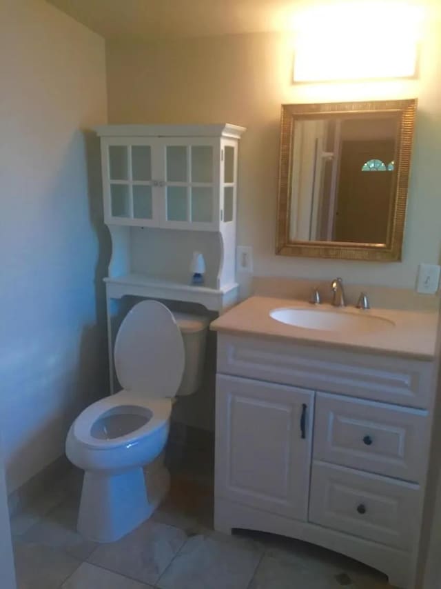 bathroom with vanity, toilet, and tile patterned flooring