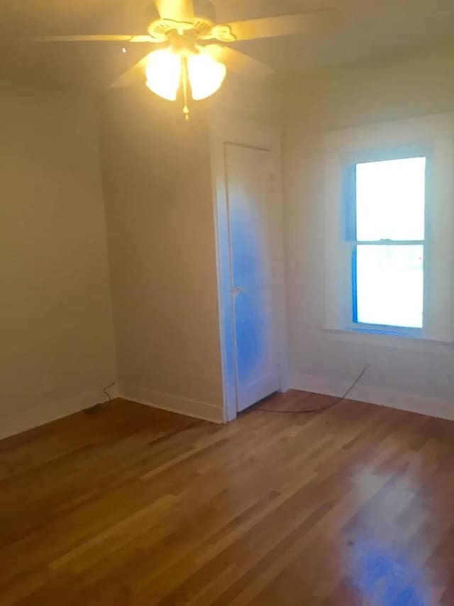 empty room with ceiling fan and hardwood / wood-style floors