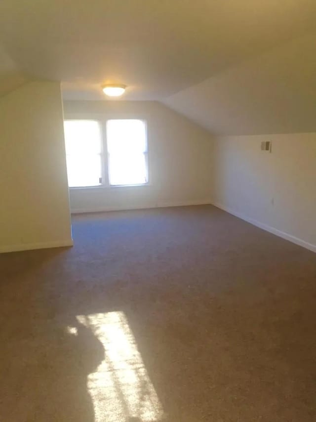 bonus room featuring lofted ceiling and carpet