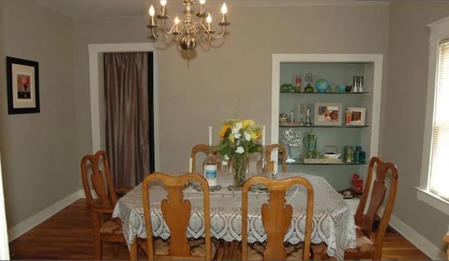 dining space featuring a notable chandelier, wood-type flooring, and built in features