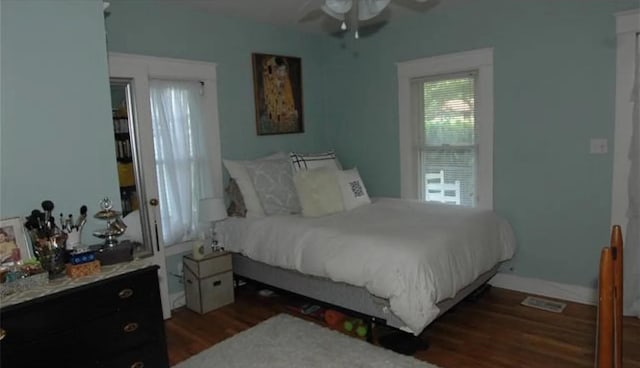 bedroom with dark hardwood / wood-style flooring and ceiling fan