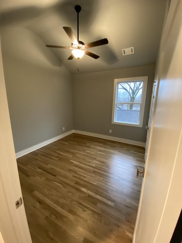 spare room with dark wood-type flooring, ceiling fan, and lofted ceiling