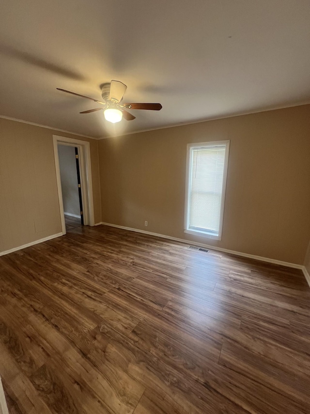 unfurnished room featuring crown molding, dark hardwood / wood-style floors, and ceiling fan