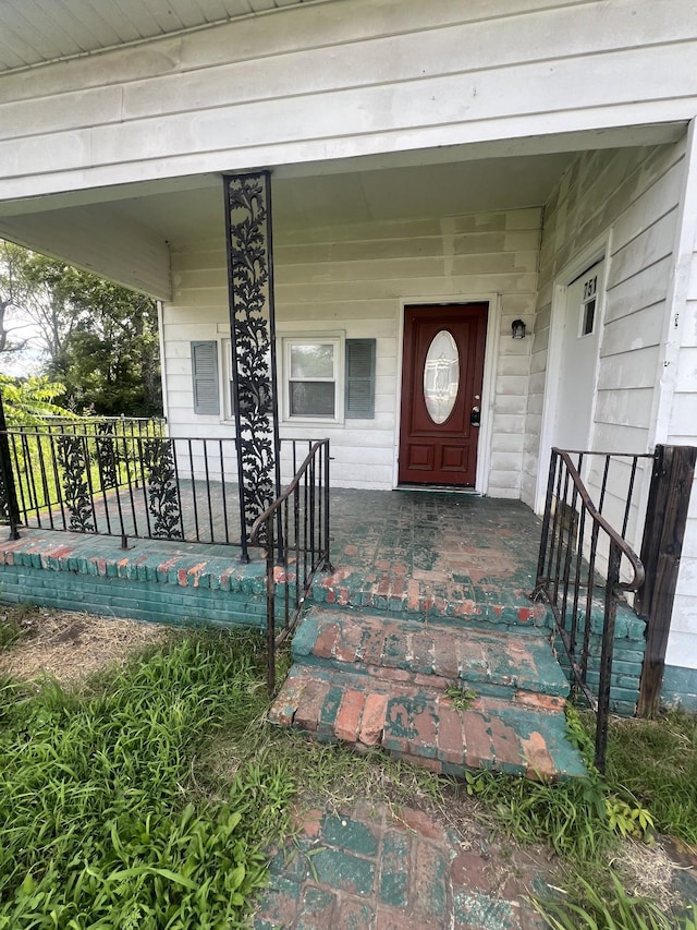 view of exterior entry featuring covered porch