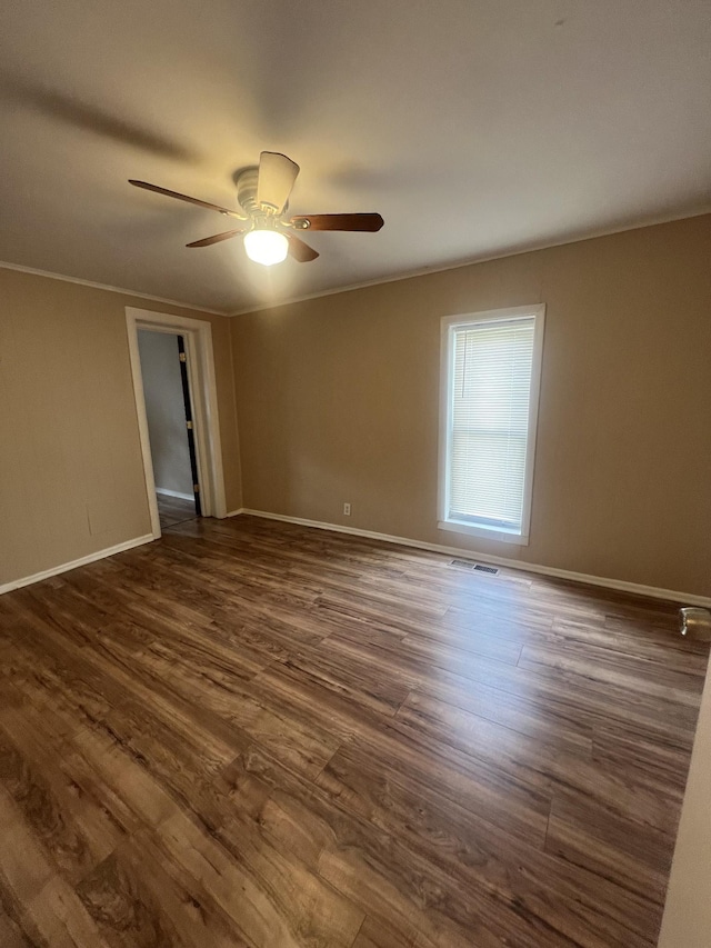 empty room featuring crown molding, ceiling fan, and dark hardwood / wood-style floors