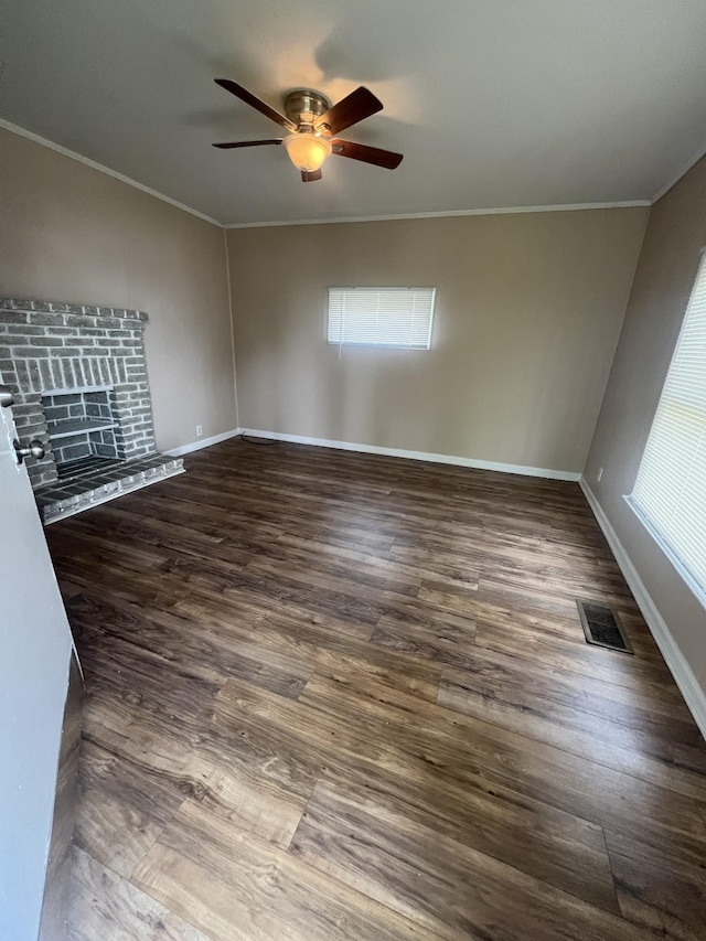 unfurnished living room featuring dark wood-type flooring, ornamental molding, and ceiling fan