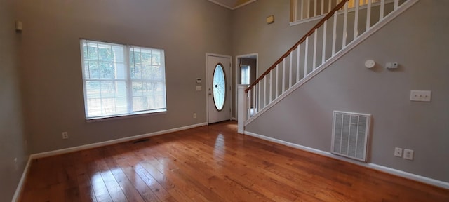 foyer entrance featuring a towering ceiling and hardwood / wood-style floors