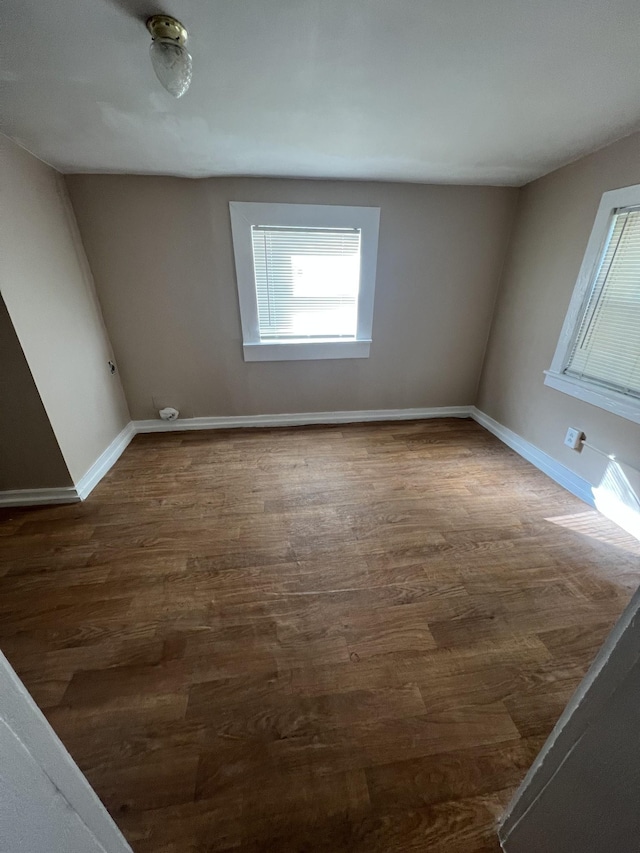 unfurnished room with plenty of natural light and dark hardwood / wood-style flooring