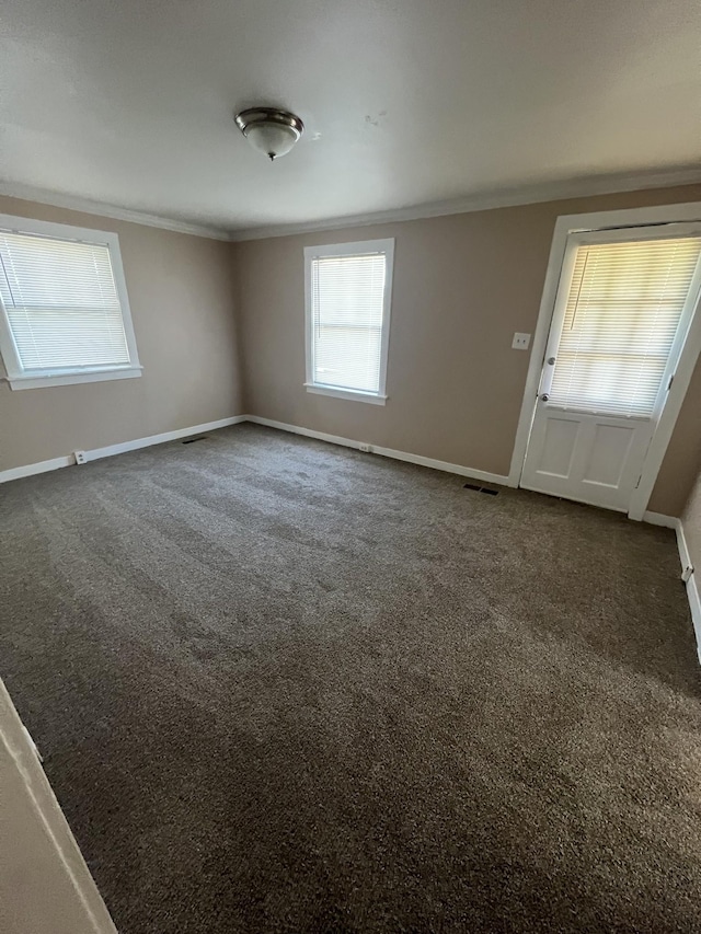 unfurnished room with crown molding and dark carpet