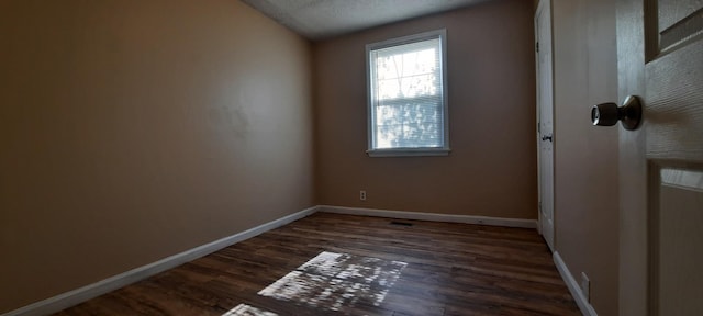 spare room featuring dark hardwood / wood-style flooring