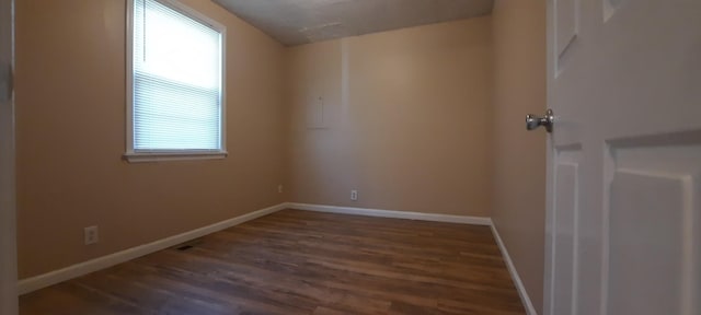 empty room with dark hardwood / wood-style floors