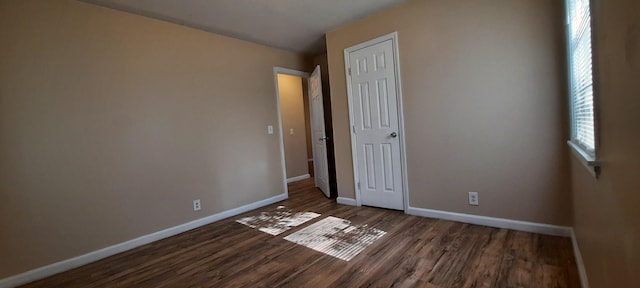 unfurnished bedroom with a closet and dark hardwood / wood-style floors