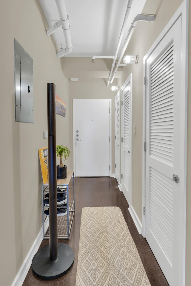 hallway featuring electric panel and baseboards