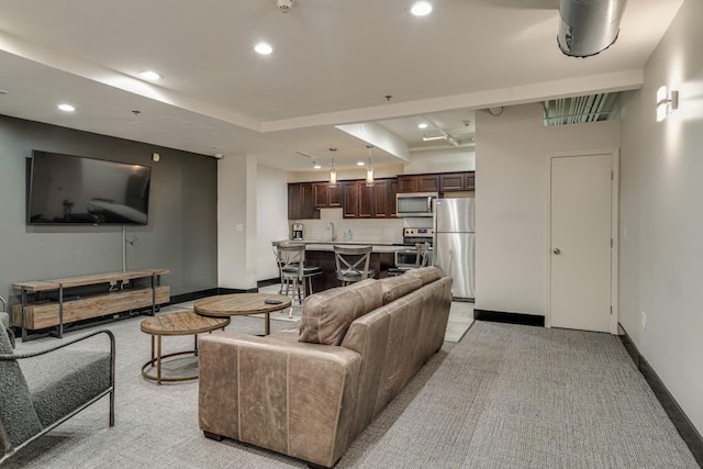 living area with light carpet, baseboards, and recessed lighting