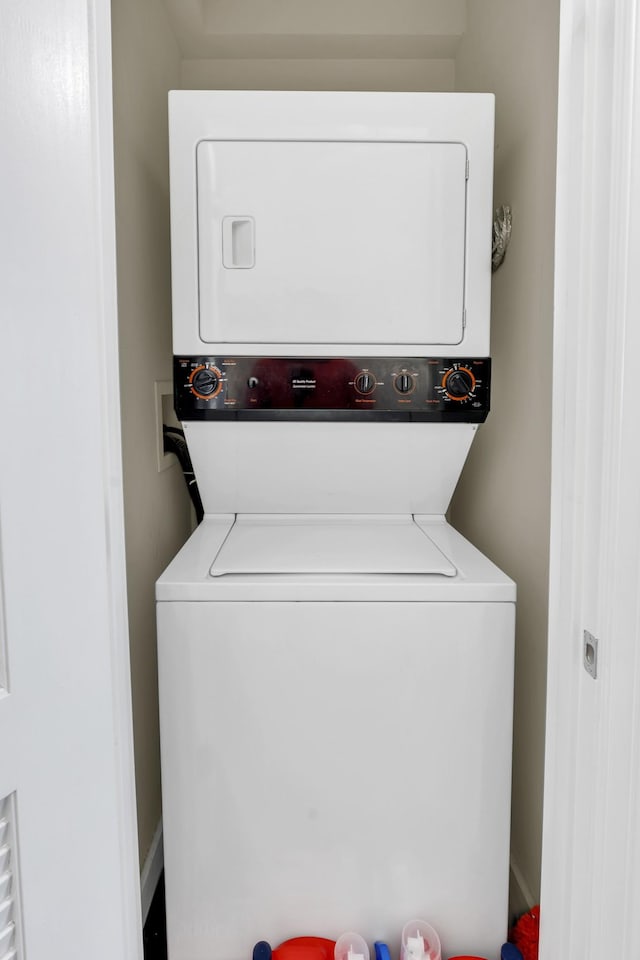 washroom with stacked washer and dryer and laundry area