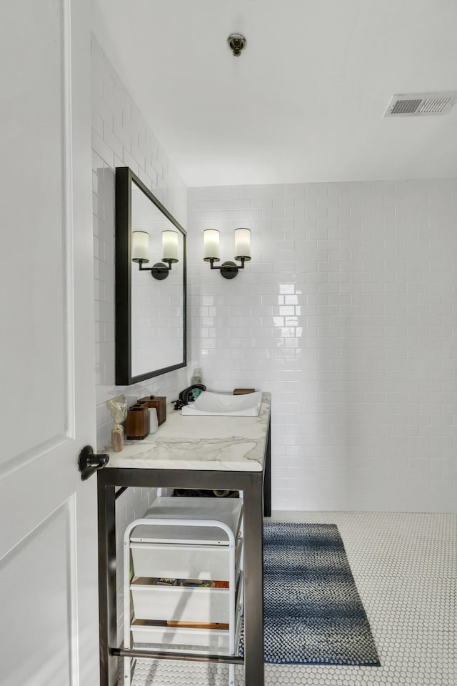 bathroom featuring vanity, backsplash, and tile walls