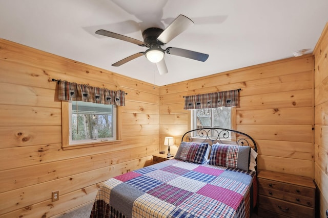 bedroom featuring wooden walls and ceiling fan