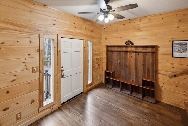 foyer with ceiling fan, wooden walls, and hardwood / wood-style floors