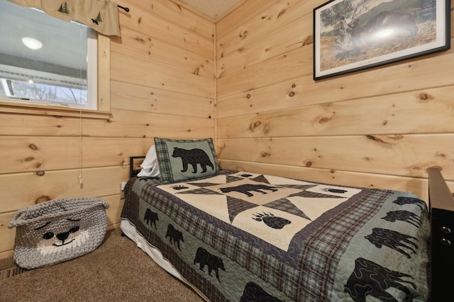 bedroom featuring carpet floors and wood walls