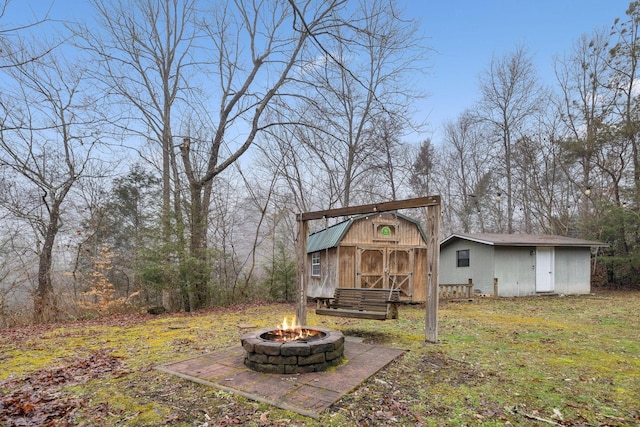 back of house with a storage unit and an outdoor fire pit