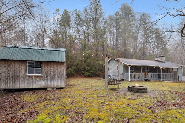 view of yard with a porch and an outdoor fire pit