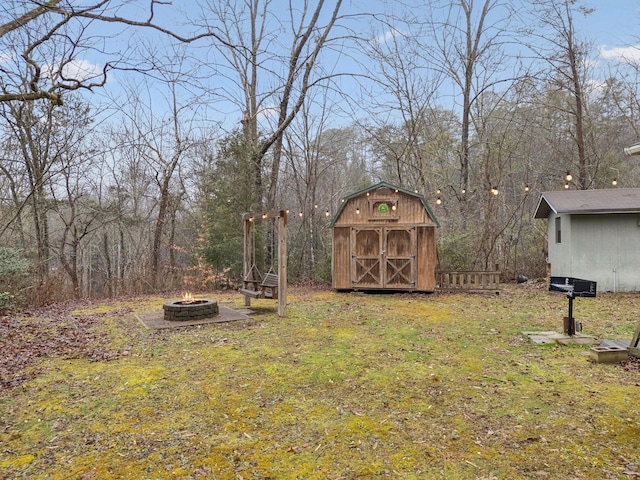 view of yard featuring a storage shed and an outdoor fire pit