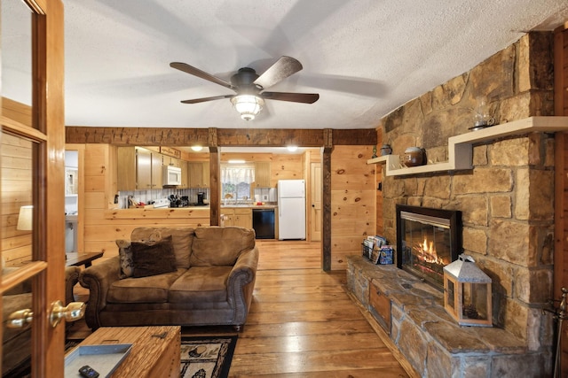 living room with wood-type flooring, a textured ceiling, and wood walls