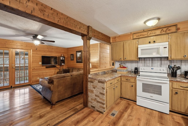 kitchen featuring white appliances, light hardwood / wood-style flooring, ceiling fan, wooden walls, and a textured ceiling