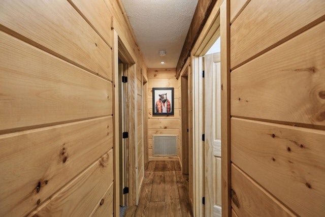 hall with dark hardwood / wood-style floors and a textured ceiling