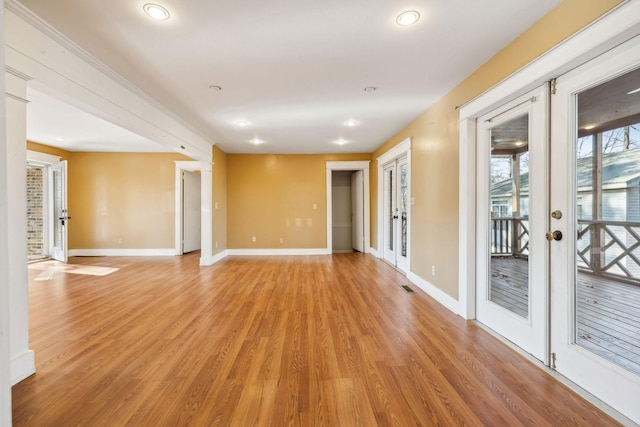 empty room with light hardwood / wood-style flooring and french doors