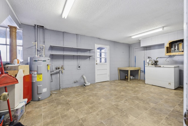 washroom with washer / clothes dryer, water heater, and a textured ceiling