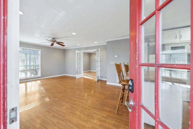 interior space featuring french doors, ceiling fan, ornamental molding, and light hardwood / wood-style flooring