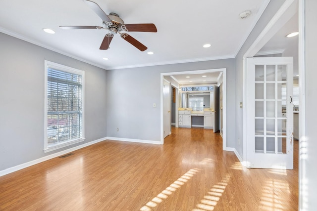 unfurnished living room featuring ornamental molding, ceiling fan, and light wood-type flooring