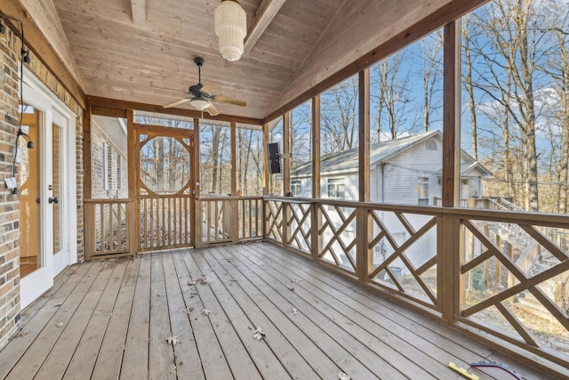 unfurnished sunroom featuring ceiling fan, lofted ceiling, plenty of natural light, and wood ceiling