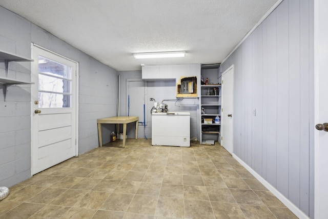 clothes washing area featuring washer / clothes dryer and a textured ceiling